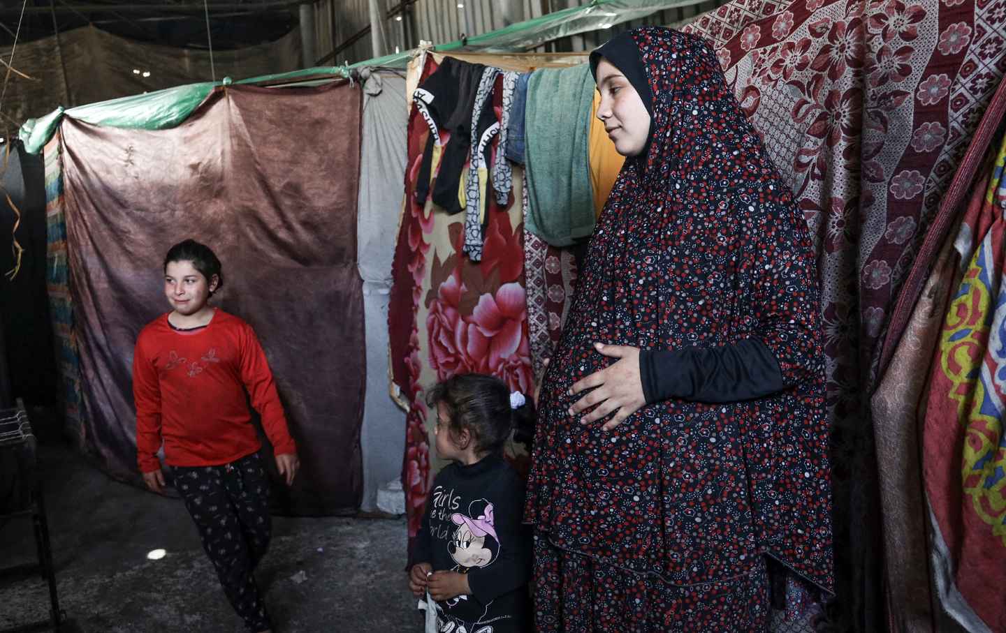 Eine schwangere Palästinenserin, die aus dem nördlichen Gazastreifen vertrieben wurde, steht am 29. Februar 2024 in einem Lagerhaus, in dem sie in Rafah im südlichen Gazastreifen Zuflucht sucht.