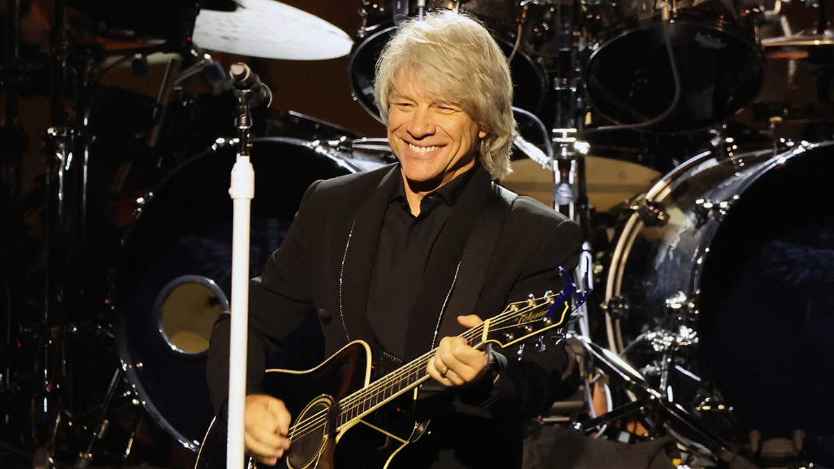 Jon Bon Jovi spielt Gitarre auf der Bühne