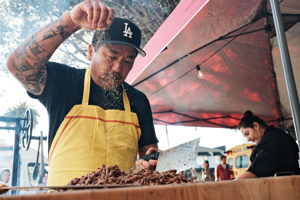 Kogi-Gründer Roy Choi streut Gewürze auf seinen Al Pastor in seinem neuen Unternehmen, dem Straßenstand Tacos por Vida in Palms.