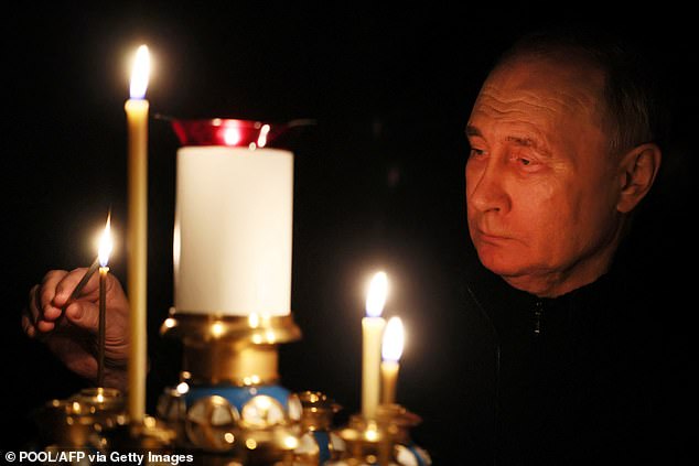 Wladimir Putin zündet bei seinem Besuch in einer Kirche der Staatsresidenz Nowo-Ogarjowo am 24. März eine Kerze an, während das Land nach dem Massaker einen nationalen Trauertag begeht