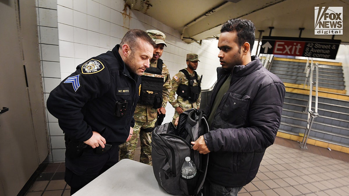 Mitglieder des NYPD und der Nationalgarde führen stichprobenartige Taschendurchsuchungen im New Yorker U-Bahn-System durch