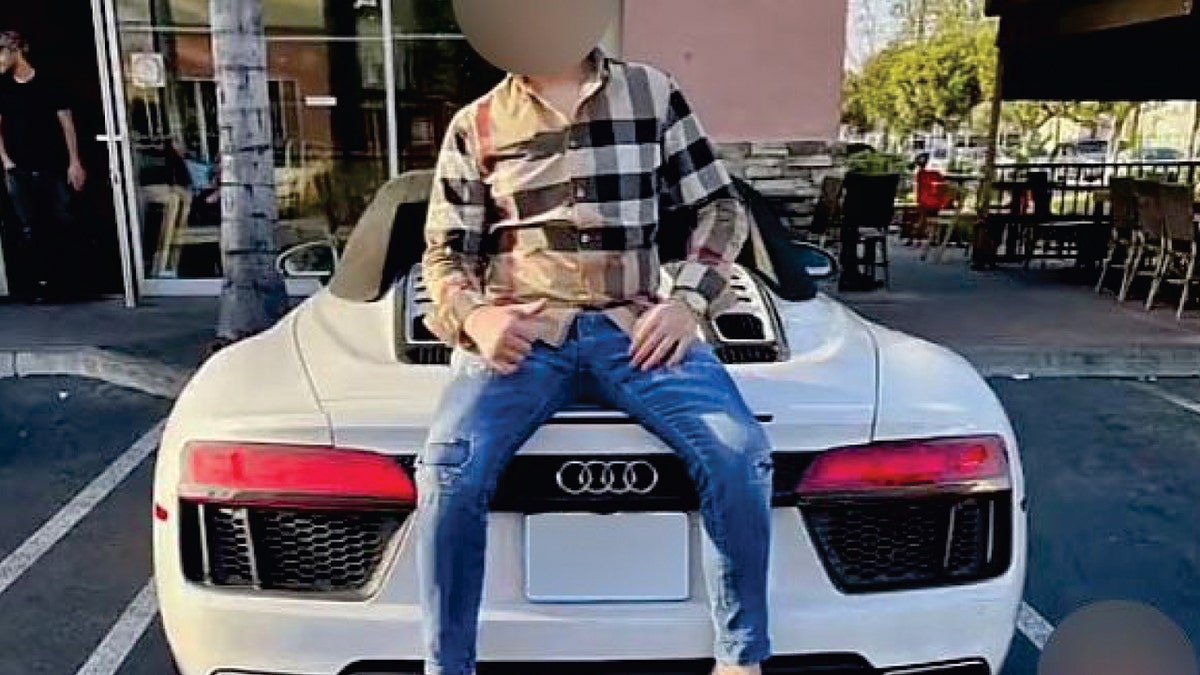 Verdächtiger trägt Designerhemd und Jeans und sitzt auf einem Audi-Sportwagen in Los Angeles
