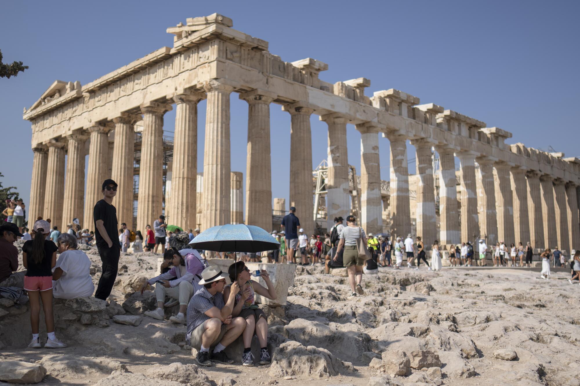 Touristen, die die Akropolis von Athen besuchen, versammeln sich rund um den Parthenon-Tempel.