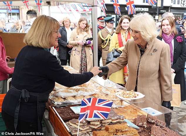 Queen Camilla meets a trader during a visit to the farmers' market in Shrewsbury today