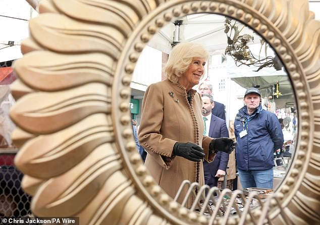 Queen Camilla reflected in a mirror during a visit to the farmers' market in Shrewsbury today