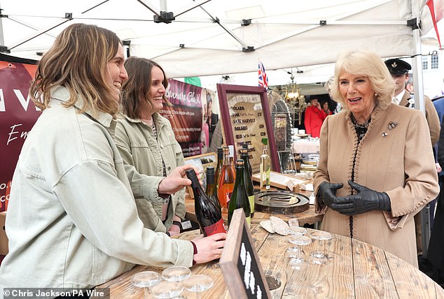 Queen Camilla speaks with market traders at a wine stall during a visit to Shrewsbury today