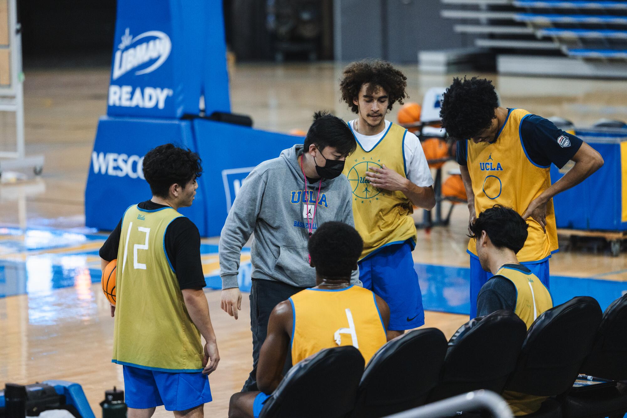 Spieler des männlichen Scout-Teams der UCLA unterhalten sich während eines Basketballtrainings für Frauen. 