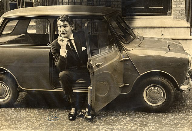 American actor Gene Barry - best remembered for his leading roles in the films The Atomic City (1952) and The War of The Worlds (1953) as well as his portrayal of the title characters in the TV series Bat Masterson and Burke's Law - pictured sitting in a Mini