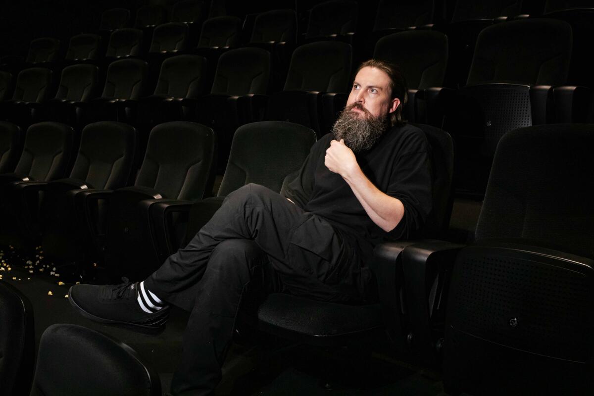 Ein Mann in Schwarz sitzt in einem Kino.