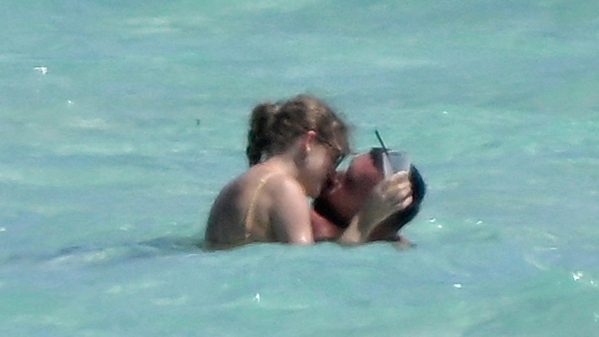 Travis Kelce und Taylor Swift küssen sich im Meer