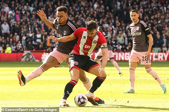SHEFFIELD, ENGLAND - MARCH 30: Sheffield United's Jack Robinson battles for possession with Fulham's Rodrigo Muniz during the Premier League match between Sheffield United and Fulham FC at Bramall Lane on March 30, 2024 in Sheffield, England.(Photo by Rich Linley - CameraSport via Getty Images)