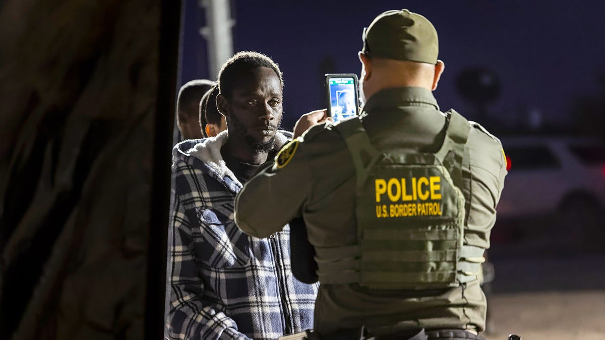 Ein Grenzschutzbeamter nimmt einen Einwanderer auf