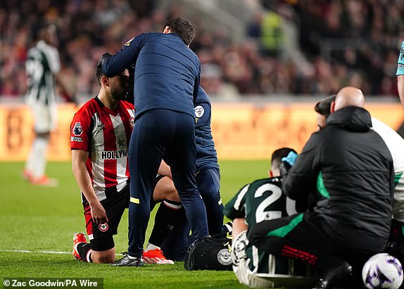 Brentford's Neal Maupay and Manchester United's Diogo Dalot receive treatment after a colinsion during the Premier League match at the Gtech Community Stadium, London. Picture date: Saturday March 30, 2024. PA Photo. See PA story SOCCER Brentford. Photo credit should read: Zac Goodwin/PA Wire.RESTRICTIONS: EDITORIAL USE ONLY No use with unauthorised audio, video, data, fixture lists, club/league logos or "live" services. Online in-match use limited to 120 images, no video emulation. No use in betting, games or single club/league/player publications.