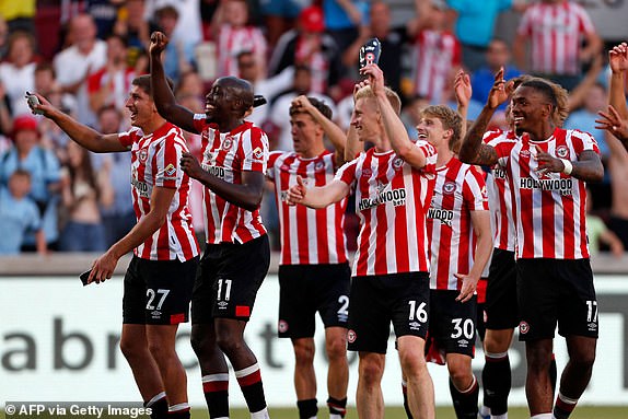 Brentford's players celebrate on the pitch after the English Premier League football match between Brentford and Manchester United at Gtech Community Stadium in London on August 13, 2022. - Bentford won the game 4-0. (Photo by Ian Kington / AFP) / RESTRICTED TO EDITORIAL USE. No use with unauthorized audio, video, data, fixture lists, club/league logos or 'live' services. Online in-match use limited to 120 images. An additional 40 images may be used in extra time. No video emulation. Social media in-match use limited to 120 images. An additional 40 images may be used in extra time. No use in betting publications, games or single club/league/player publications. /  (Photo by IAN KINGTON/AFP via Getty Images)