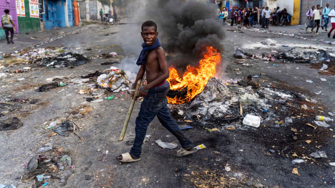 Ein Mann geht letztes Jahr während einer Protestaktion gegen den haitianischen Premierminister Ariel Henry in Port-au-Prince an einer brennenden Barrikade vorbei.
