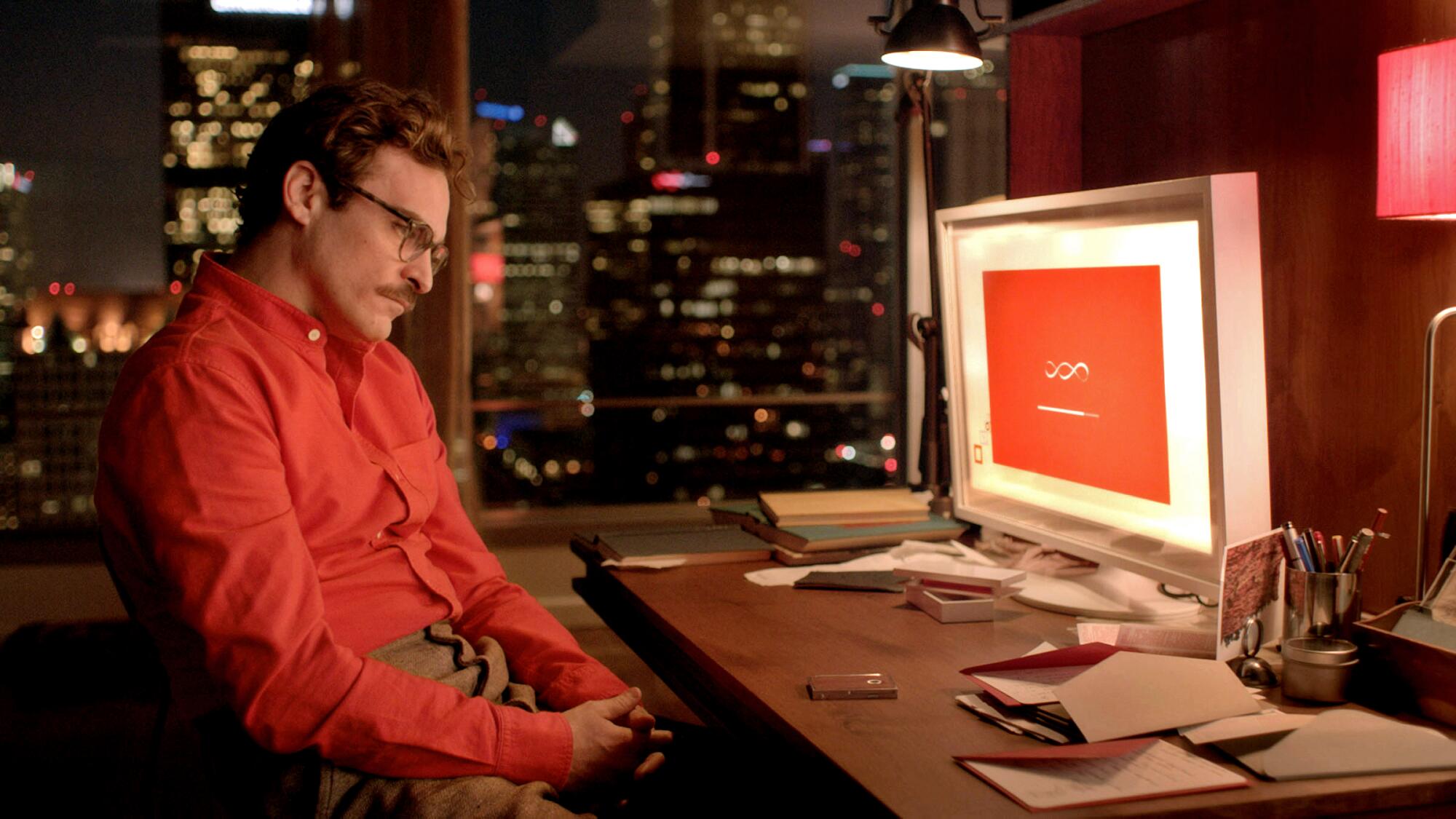 Joaquin Phoenix als Theodore im Film "Ihr," am Computertisch sitzen. 