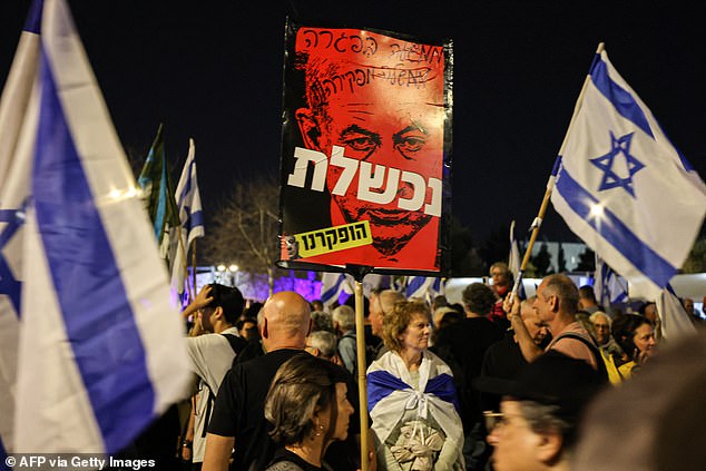 Demonstranten halten Plakate in die Höhe und fordern, dass Herr Netanjahu sein Amt niederlegt.  Familien von Geiseln sagen, der Premierminister sei ein „Hindernis für eine Einigung“
