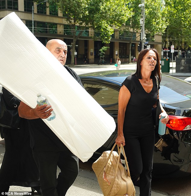 Aggie Di Mauro und Celestes Vater Tony betreten am Donnerstag den Obersten Gerichtshof von Victoria und tragen die Asche ihrer Tochter unter einer weißen Decke