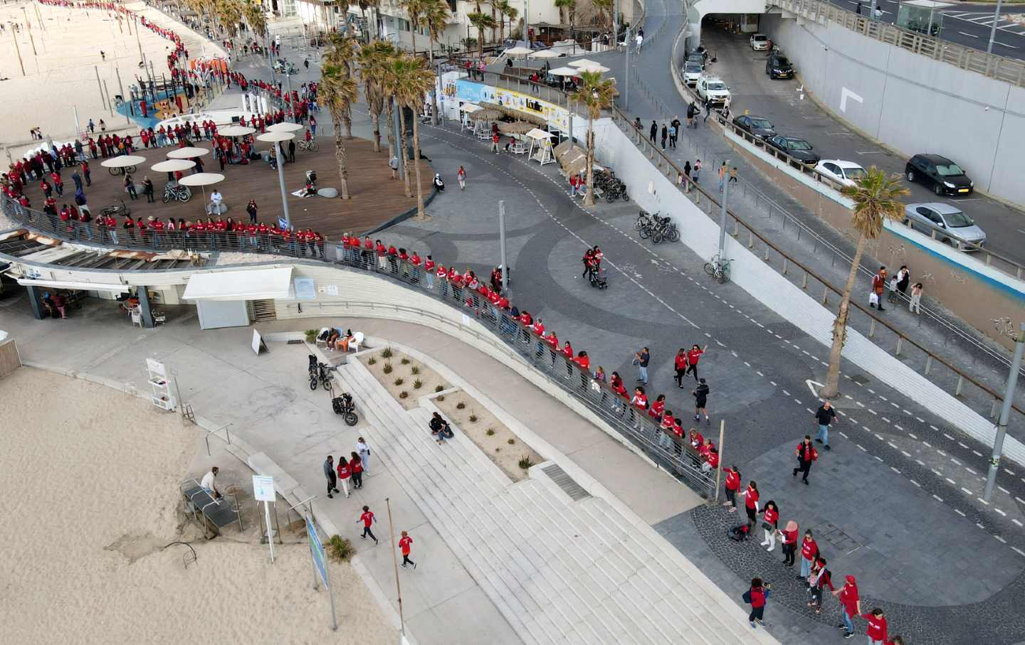 Auf dieser Luftaufnahme sind rot gekleidete Demonstranten, die sich für Frauenrechte einsetzen, am 8. März 2023 in Tel Aviv eine Menschenkette, die am Internationalen Frauentag stattfindet.
