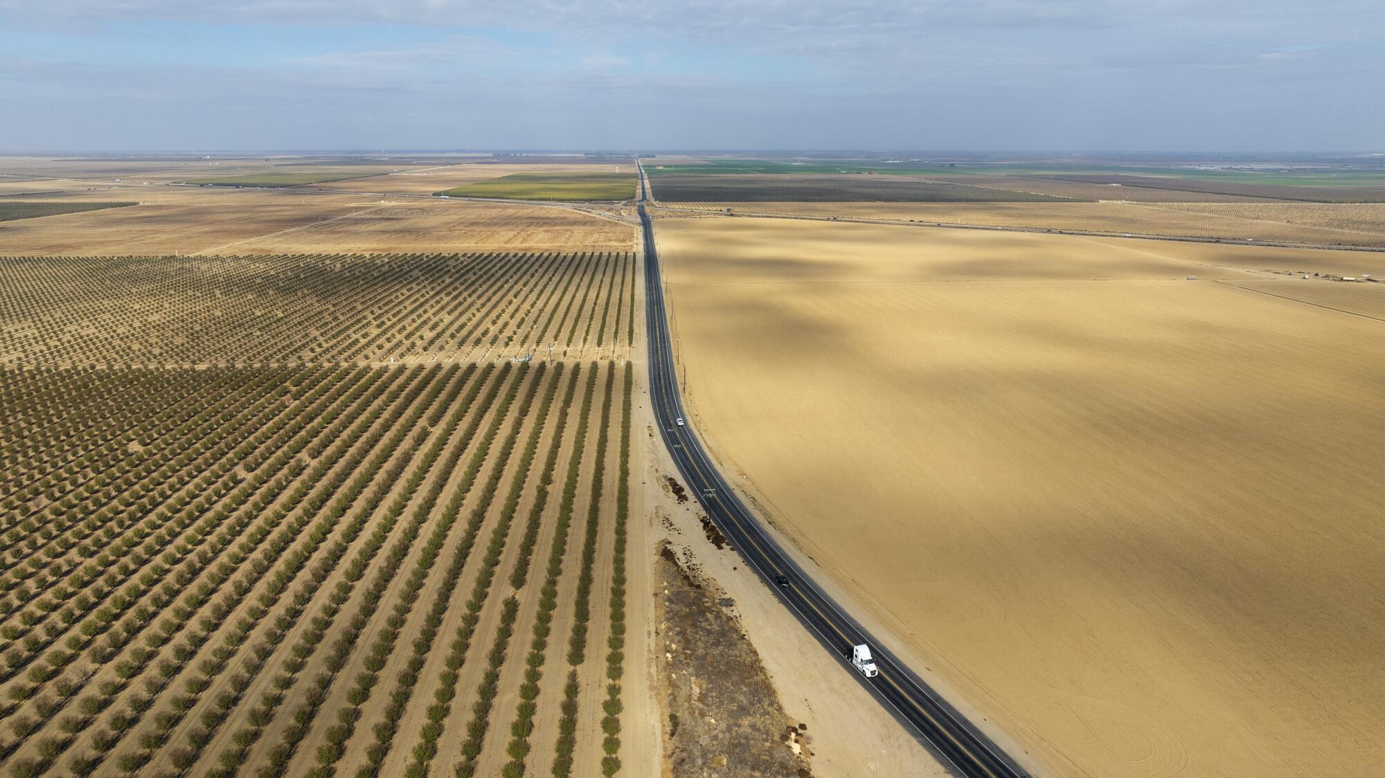 Eine Luftaufnahme von Ackerland und Mandelplantagen, die von einer Autobahn durchquert werden.