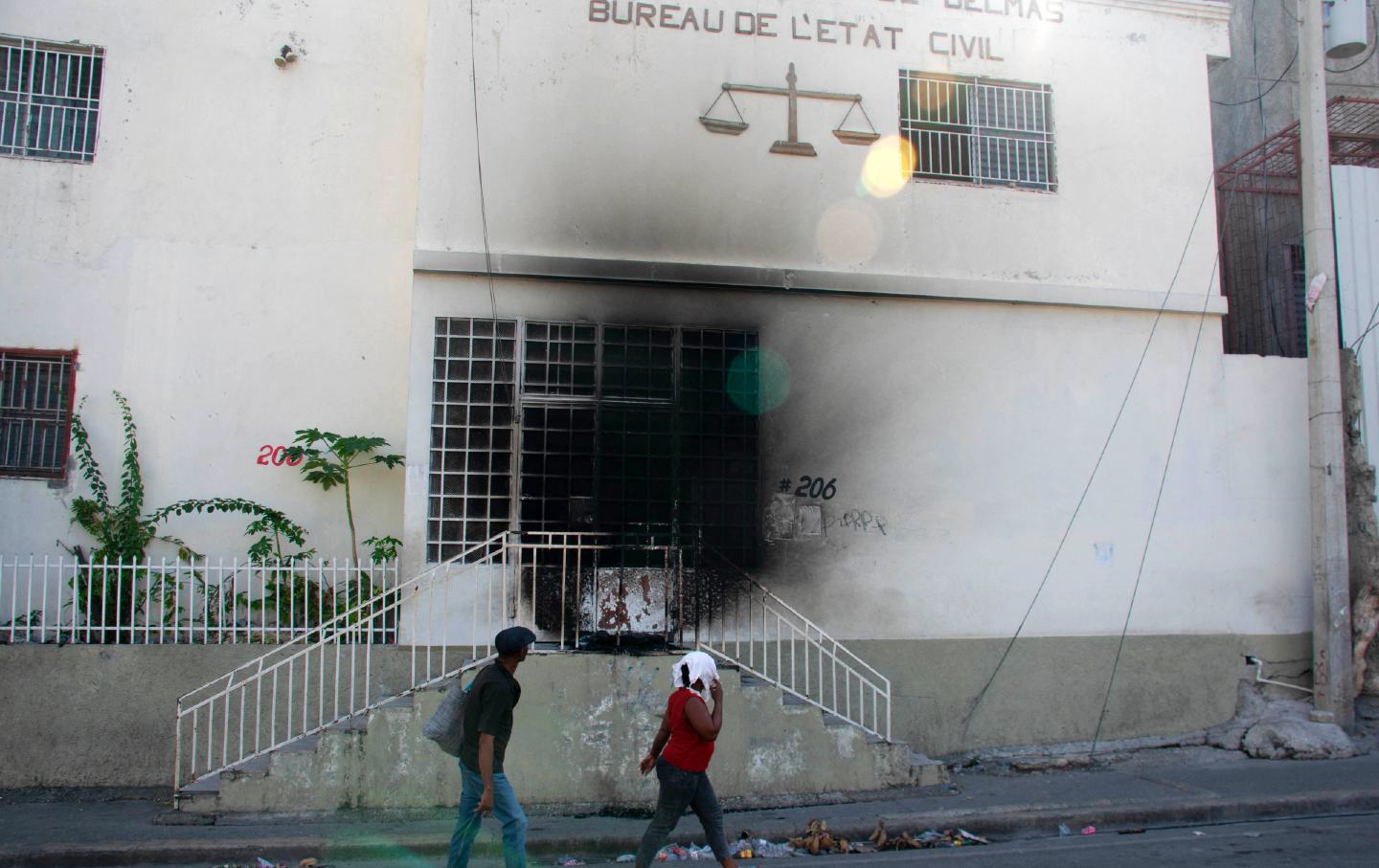 Am 6. März 2024 gehen Menschen an dem Tribunal vorbei, das am Vortag von bewaffneten Banden in Port-au-Prince, Haiti, in Brand gesteckt wurde. Haitis Hauptstadt wurde am 4. März weitgehend geschlossen, da die Behörden nach einem Angriff den Ausnahmezustand verhängten Ein Gefängnis befreite Tausende von Insassen.