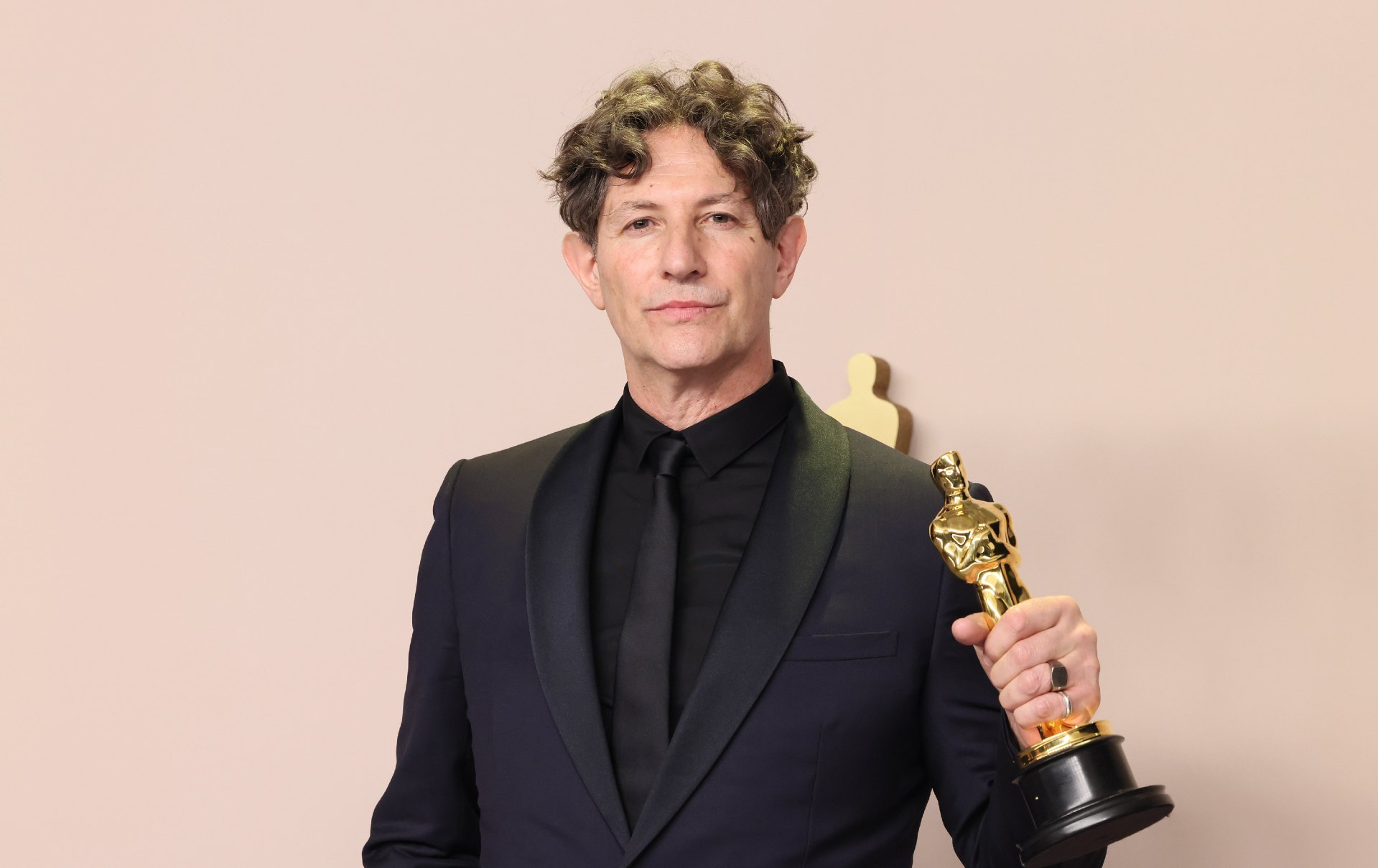 Jonathan Glazer hält eine Oscar-Statuette in der Hand