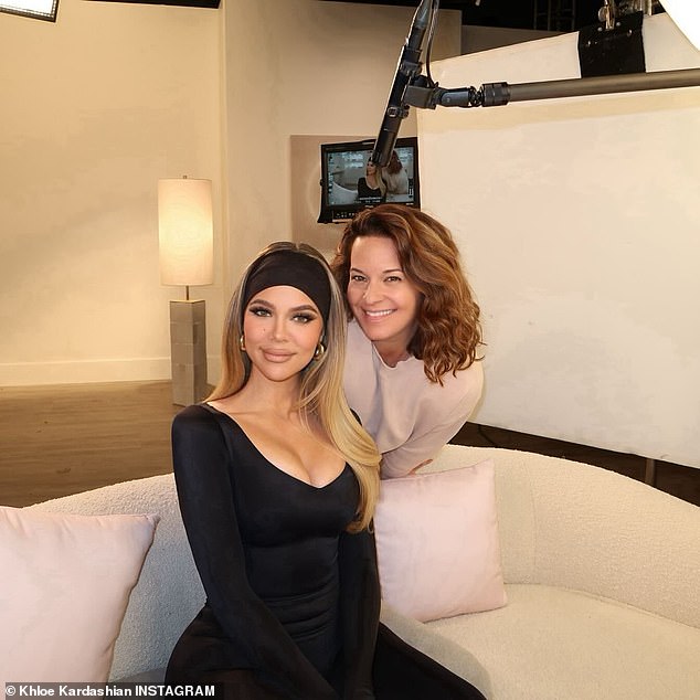 Auf diesem neuen Bild trägt Khloe auch ein tief ausgeschnittenes schwarzes Top mit passenden Leggings, während sie auf einem cremefarbenen Sofa mit Kissen sitzt und ein Mikrofon über ihren Kopf hält.  Hinter ihr steht eine Frau in einem weißen Top, im Hintergrund ist ein Bildschirm mit Khloes Bild zu sehen.  Die Überschrift lautet: „Ich und mein Paxy PP.“  Möglicherweise arbeitet sie an der Reality-TV-Show für Hulu mit dem Titel „The Kardashians“.