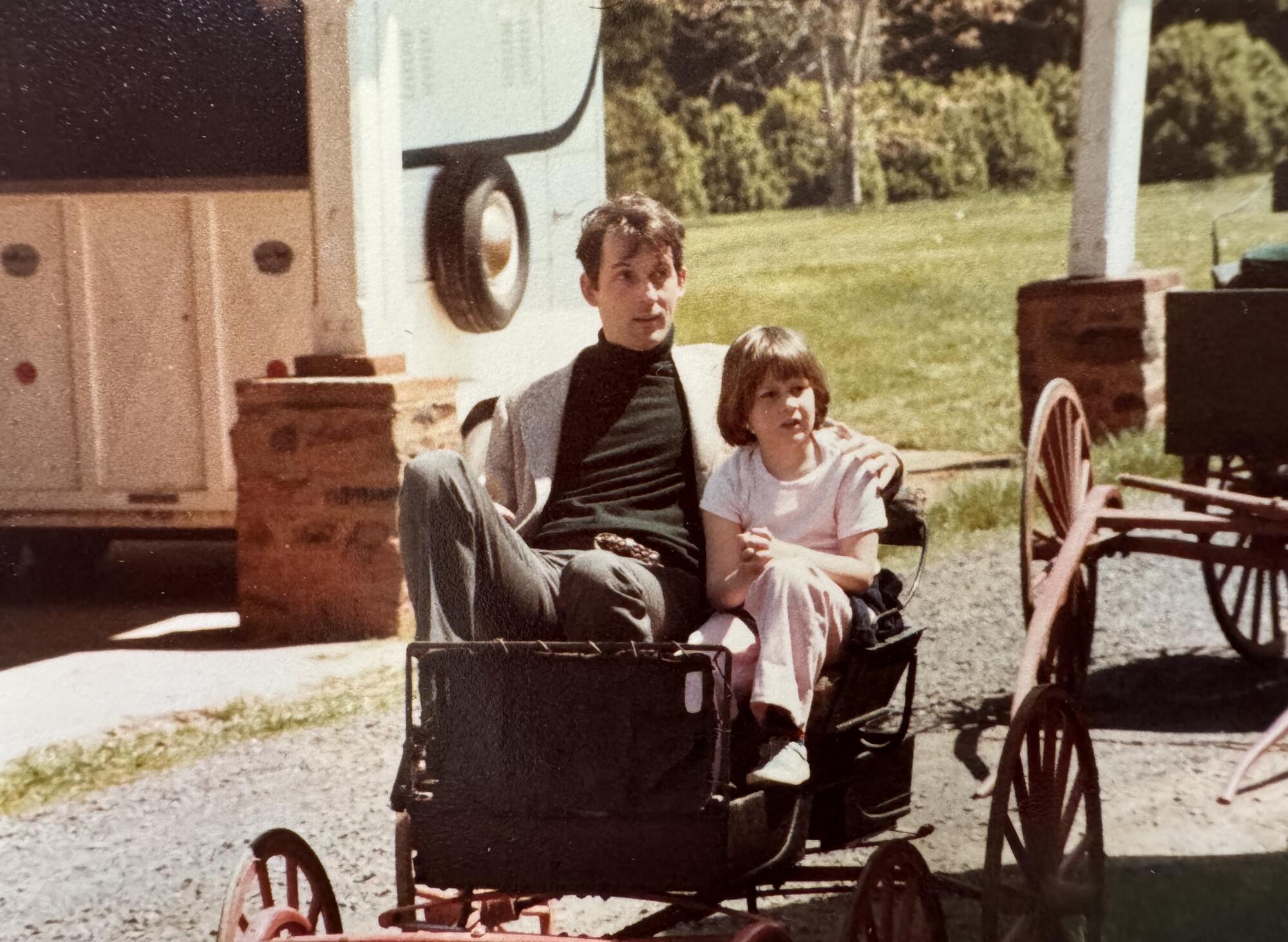 Ein Vater und eine Tochter sitzen zusammen in einem Karren.  