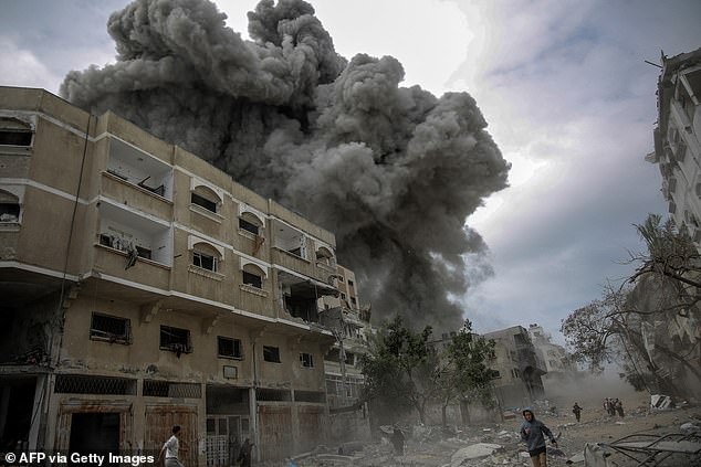 Nach dem israelischen Bombardement im Zentrum von Gaza-Stadt am 18. März 2024, inmitten der anhaltenden Kämpfe zwischen Israel und der militanten Gruppe Hamas, eilen Palästinenser in Deckung, während Rauch aufsteigt