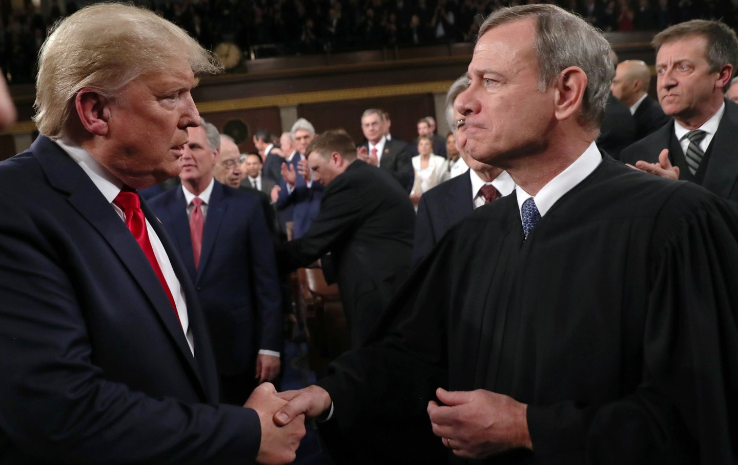 Präsident Donald Trump schüttelt dem Obersten Richter des Obersten Gerichtshofs, John Roberts, vor der Rede zur Lage der Nation am 4. Februar 2020 im Plenarsaal des Repräsentantenhauses in Washington, D.C. die Hand