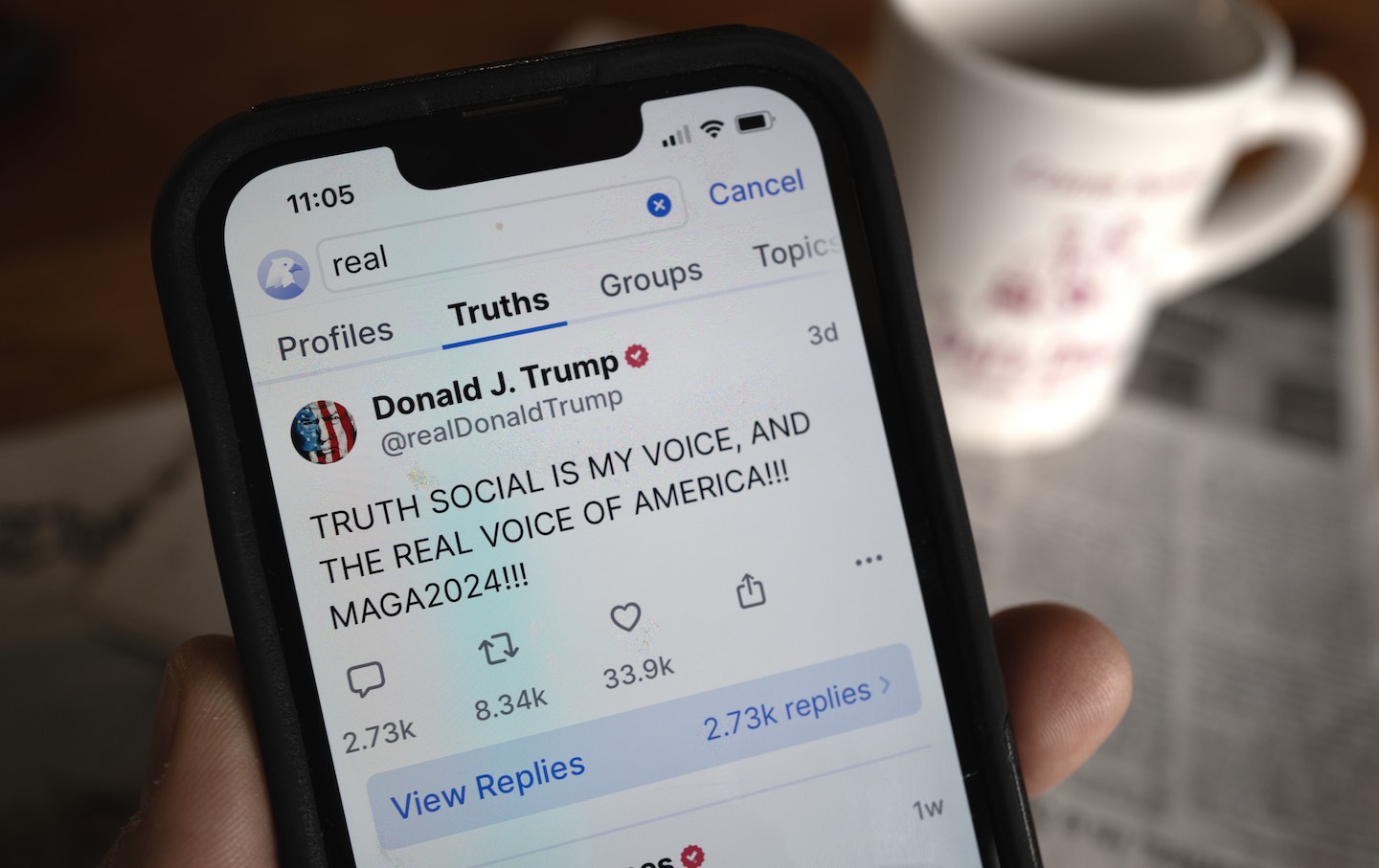 Auf einem Handy ist Donald Trumps Social-Media-Plattform Truth Social zu sehen.