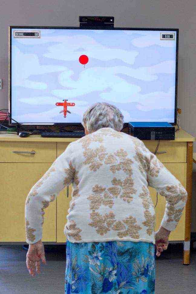 An elderly person performs movements in front of one of the games designed by NaturalPad