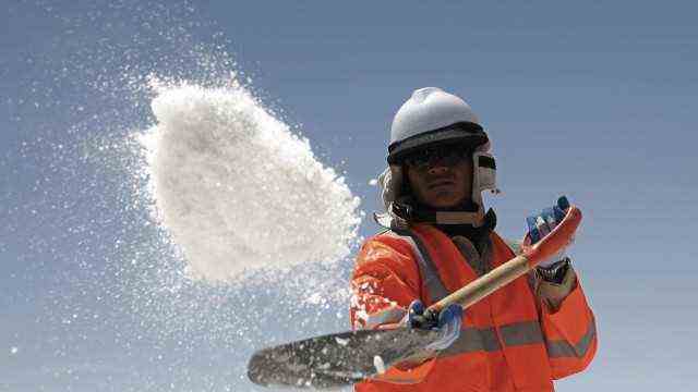 A worker throws salt at Uyuni salt lake