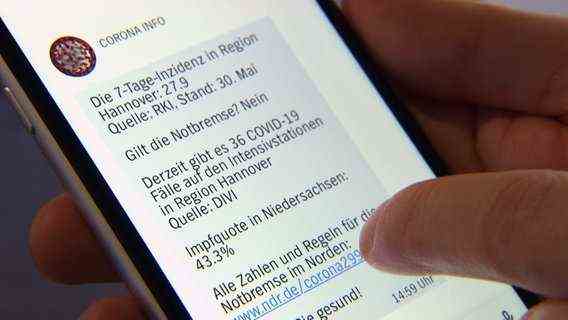 A person looks at the current corona information in the NDR Lower Saxony app on a smartphone screen.  © NDR 