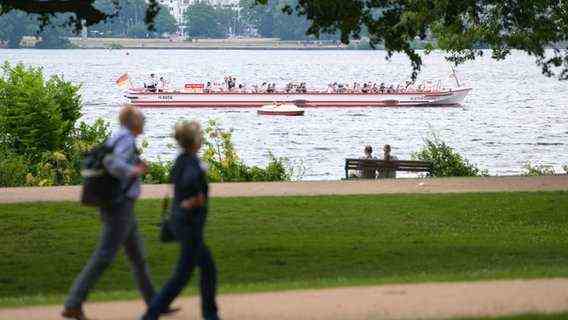 Day trippers go for a walk along the Alster while an Alster steamer goes by.  © picture alliance / dpa |  Jonas Walzberg Photo: Jonas Walzberg