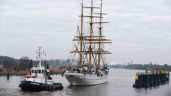 A tug is driving behind the training ship Gorch Fock, which has just passed the Huntes barrier.  © dpa photo: Carmen Jaspersen