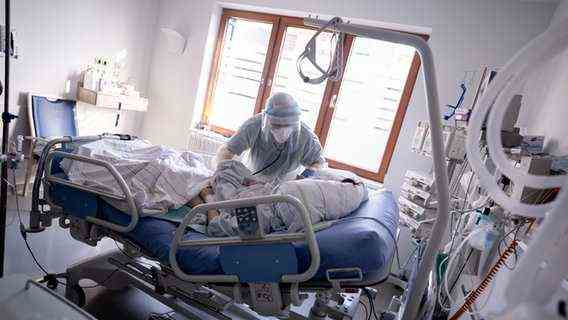 An intensive care nurse takes care of a patient suffering from Covid-19 in a hospital.  © dpa Photo: Kay Nietfeld
