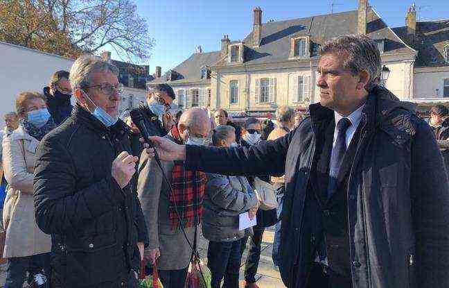 Arnaud Montebourg holds up the microphone to answer questions. 