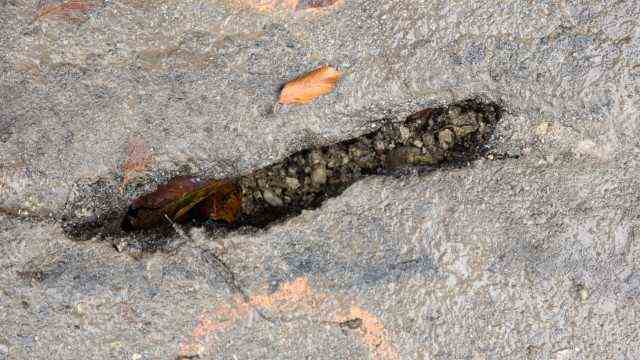 Climate change: After the heavy rain, the asphalt shows several cracks that look like wounds.