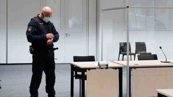 Before the trial of a 96-year-old former secretary of the SS commandant of the Stutthof concentration camp, a judicial officer looks at his watch in the courtroom © dpa Photo: Markus Schreiber