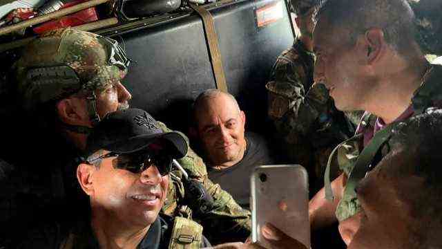 Dairo Antonio Usuga David, alias 'Otoniel', top leader of the Gulf clan, poses for a photo while escorted by Colombian military soldiers inside a helicopter after being captured, in Turbo
