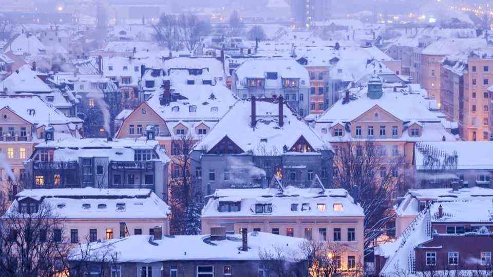 Saxony, Leipzig: Chimneys smoke in the morning on the roofs of Leipzig's southern suburb.  However, heating professionals show how they can save a small fortune in winter.