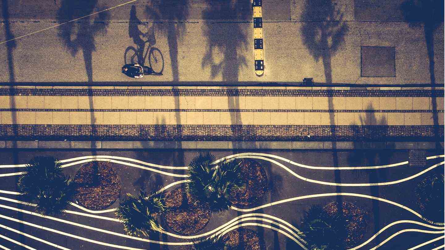 Drone photo of a cyclist driving through the Superkilen Park, a square designed with white lines.