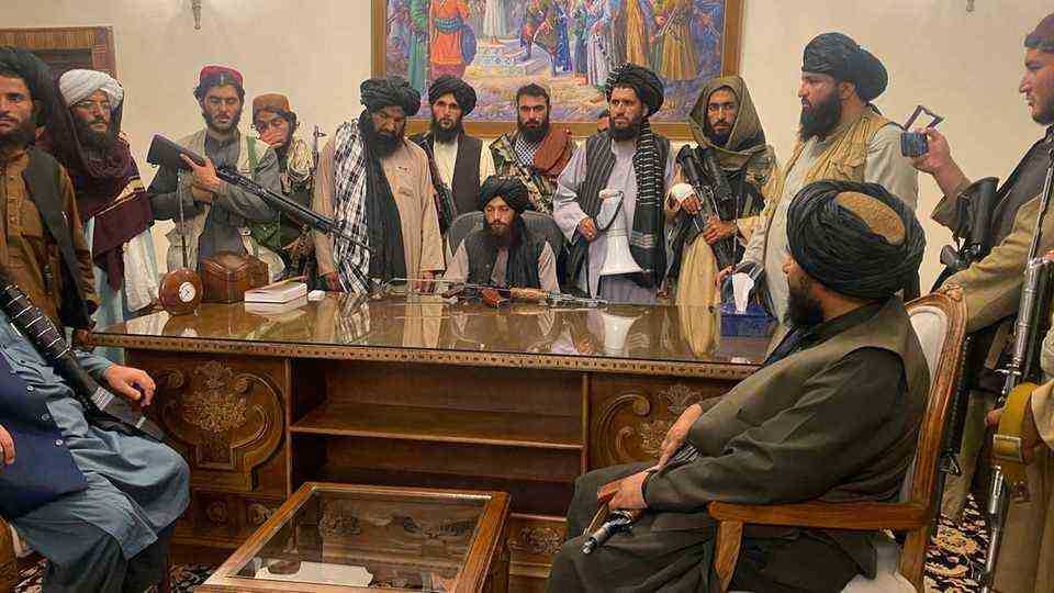 Taliban fighters sit in a room of the Presidential Palace in Kabul, Afghanistan