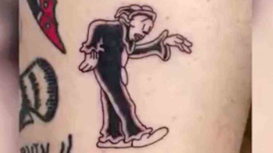 A fresh tattoo on skin shows a dancing clown