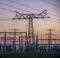 At the substation with its widely visible power pylons, a colorful sunrise announces itself.