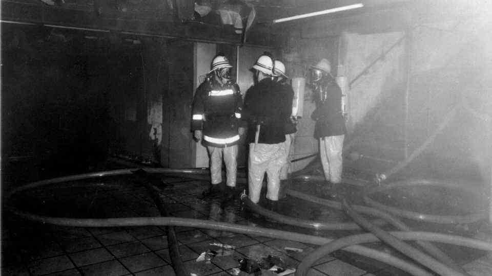 Firefighters stand in King's Cross tube station in London after the extinguishing work
