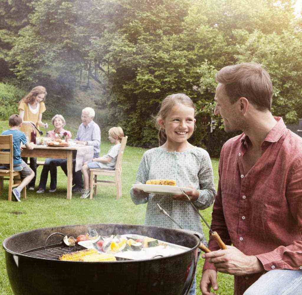 Smiling father and daughter on a family barbecue