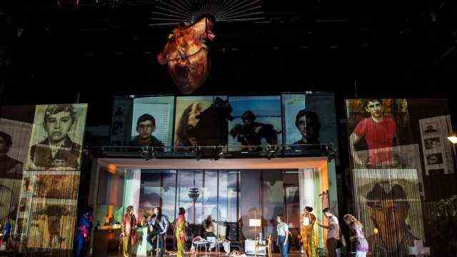 Theater: In the background of the stage, social media messages run like a digital waterfall through the stage set, which consists of a mixture of Nivedita's student apartment and Saraswati's sophisticated living room.