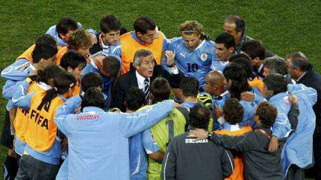 Uruguay's head coach Oscar Washington Tabarez talks to his team before the start of extra time at Soccer City stadium